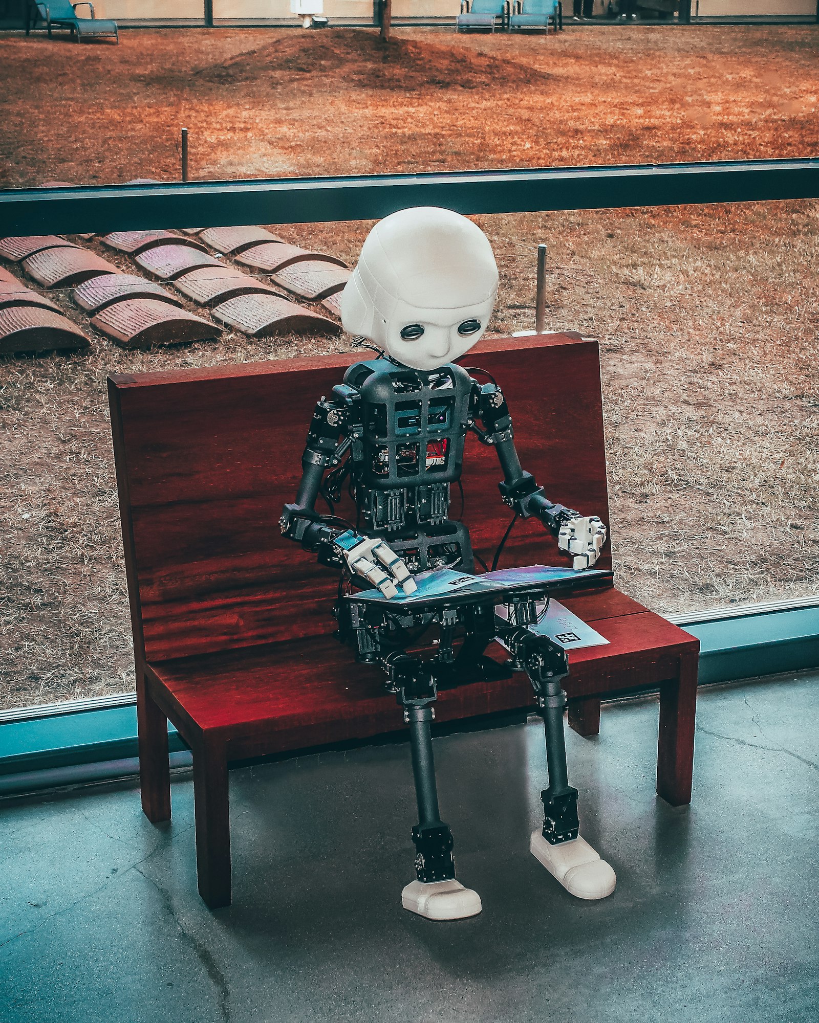 Small toy robot sitting on a bench