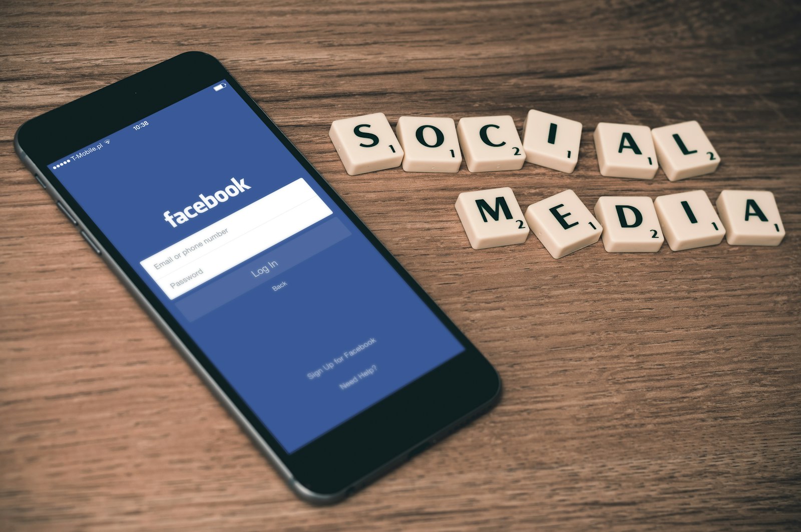 Phone showing a social media app beside letter tiles spelling social media